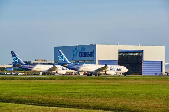 Des avions d'Air Transat devant un hangar.