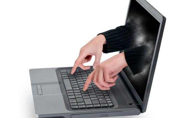 Des mains qui sortent d'un écran d'ordinateur.
