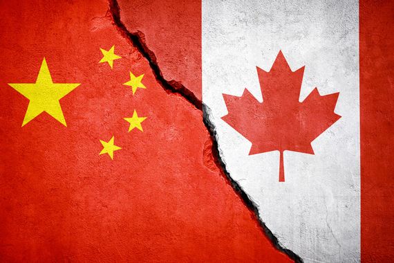 Les drapeaux de la Chine et du Canada peints sur un mur fissuré.