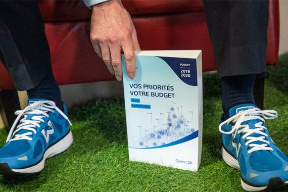 Les nouveaux souliers du ministre des Finances, Éric Girard, avec le livre sur le budget.