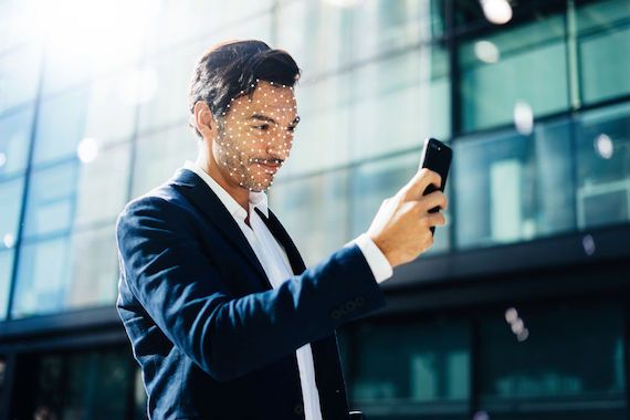 Un homme débarre son téléphone cellulaire avec la fonction Face ID de son téléphone.