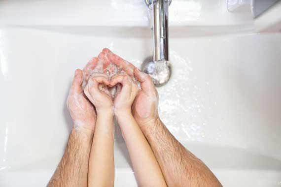 Un papa et un enfant qui se lavent les mains.