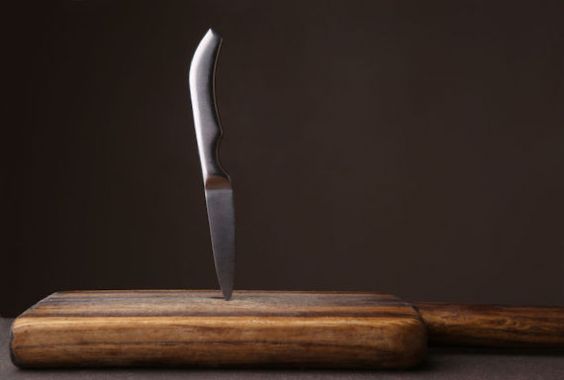 Un couteau planté dans une planche de bois