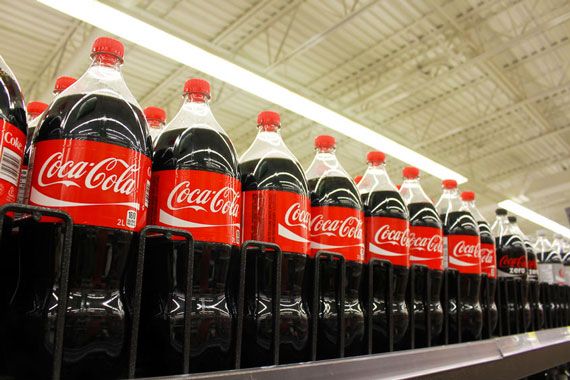 Un étalage rempli de bouteilles de 2L de Coca Cola.