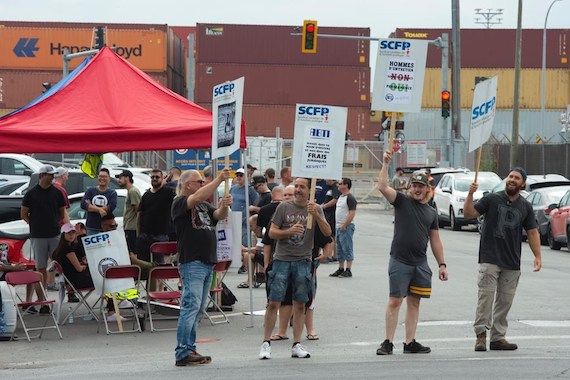 Des gens manifestent devant le port de Montréal