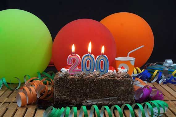 Un gâteau d'anniversaire décoré de trois chandelles montrant le chiffre 200.