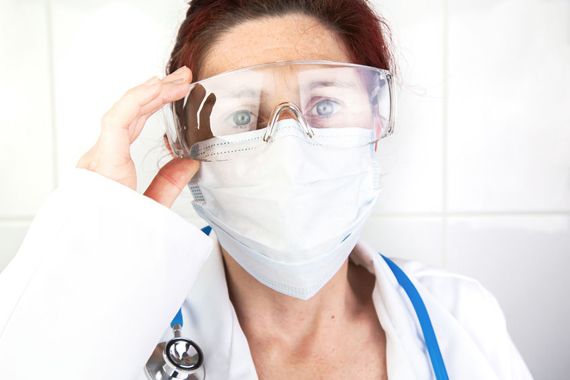 Une travailleuse de la santé portant un masque et des lunettes de protection.