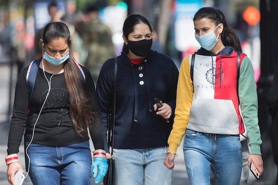 Trois jeunes femmes qui portent un masque