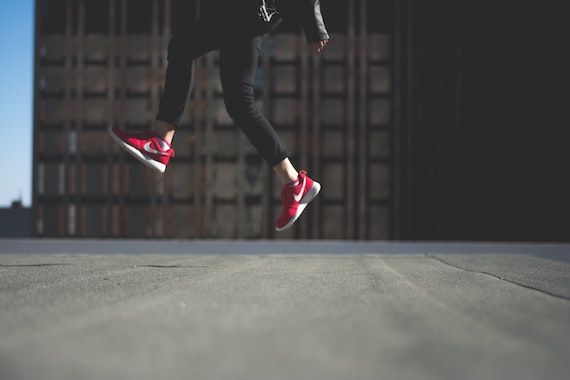 Une femme saute, running shoes aux pieds