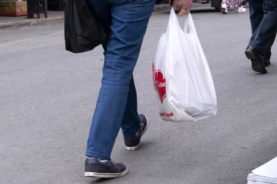 Un homme tenant un sac de plastique.
