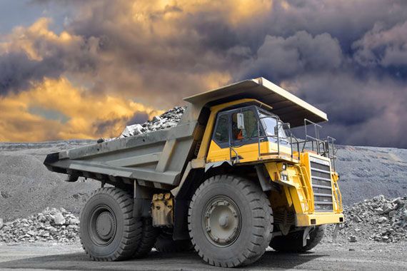 Camion sur une exploitation minière sous des nuages menaçants.