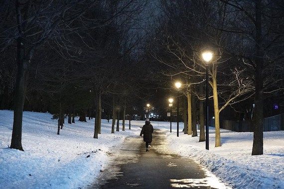 Une personne marche seule dans un parc la nuit