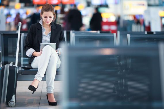Une femme attend dans un aéroport.