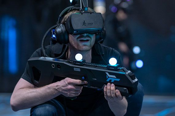 Homme avec casque réalité virtuelle et fusil