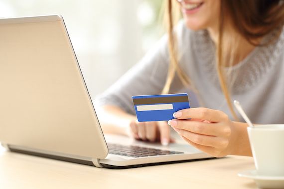 Une femme fait des achats en ligne avec sa carte de crédit.