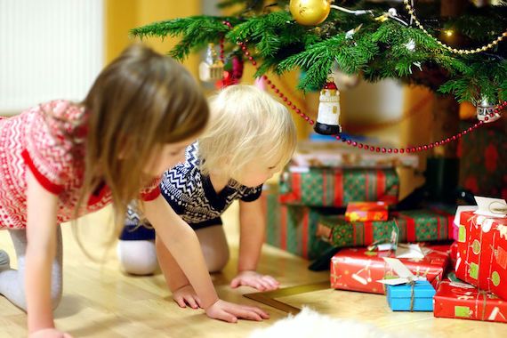 Des enfants regardent les cadeaux sous le sapin