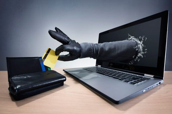 Une main qui sort d'un écran d'ordinateur pour aller piger dans un portefeuille.