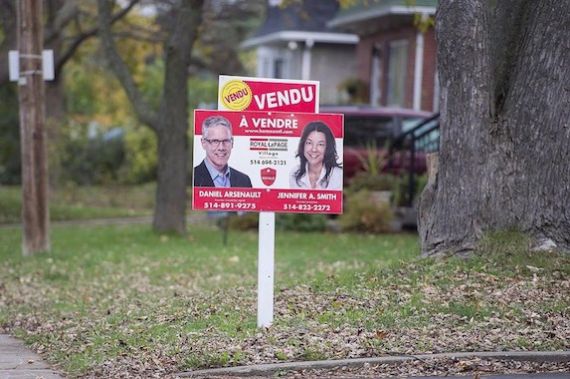 Une pancarte d'agents immobiliers annonce la vente d'une maison.