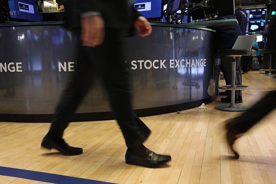 Des pieds de gens qui passent devant le logo de la Bourse de New York