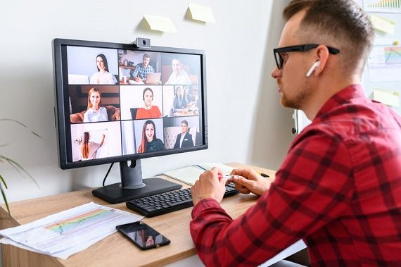 Un homme devant un ordinateur en vidéoconférence