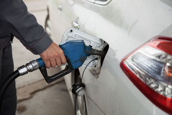 Un automobiliste mettant de l'essence dans sa voiture.