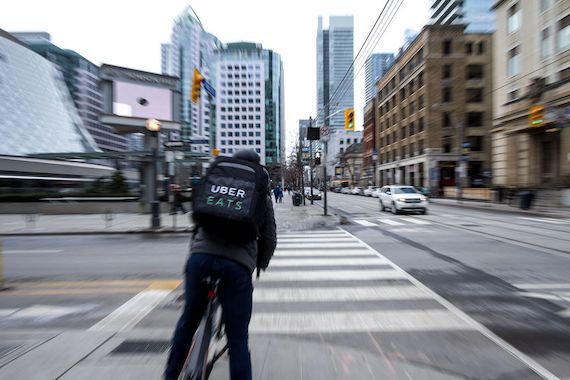 Un livreur de Uber Eats à vélo dans les rues de Toronto.