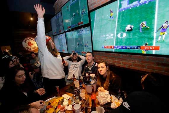 Des gens qui regardent le Super Bowl dans un bar.