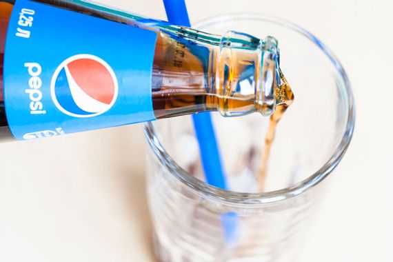 Une bouteille de Pepsi versée dans un verre.