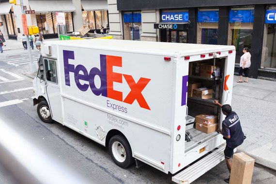Un homme remplit un camion de livraison de FedEx