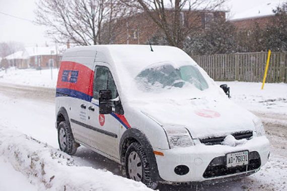 Camion de Postes Canada recouvert de neige.