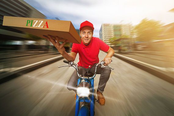 Un livreur de pizza sur un scooter