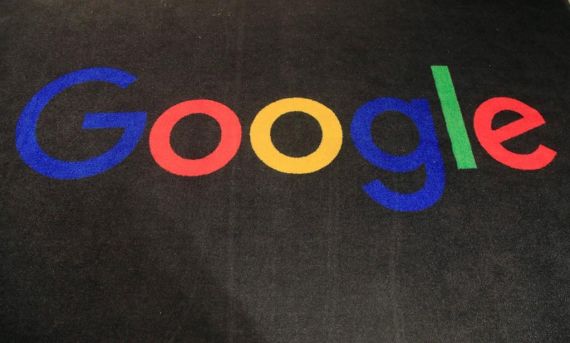 Le logo de Google est photographié sur un mur noir.