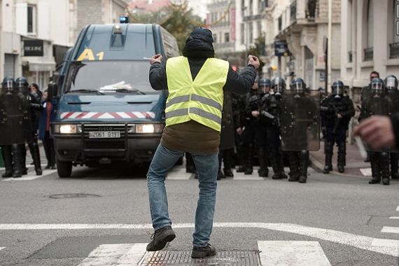 Un homme habillé d'un gilet jaune proteste devant un barrage de policiers à Biarritz.