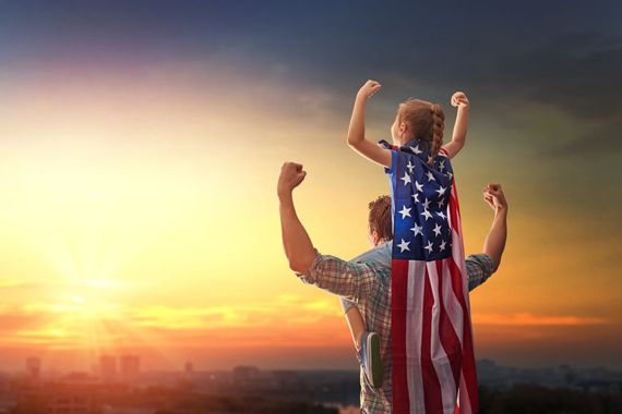 Un père et sa fille avec un drapeau américain.