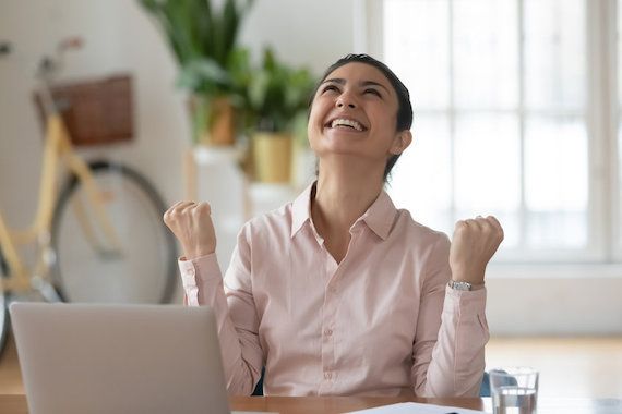 Une femme heureuse devant son poste de travail